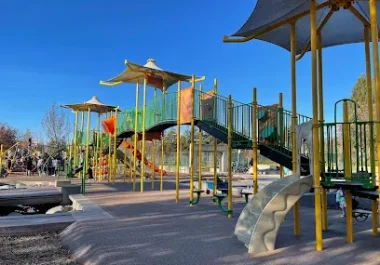 Community playground with yellow canopy structures, slides, and climbing equipment in Central Park, San Ramon