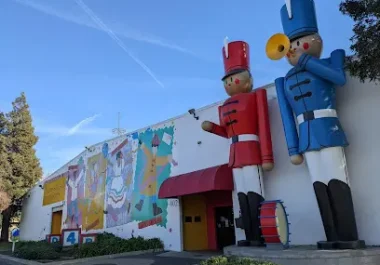 Colorful children's museum building with giant toy soldier statues and playful murals